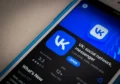 Логотип ВКонтакте на экране iPhone: сообщение о недоступности приложения в App Store