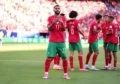 Футбольное поле: игроки в ярких розовых бутсах во время матча чемпионата мира