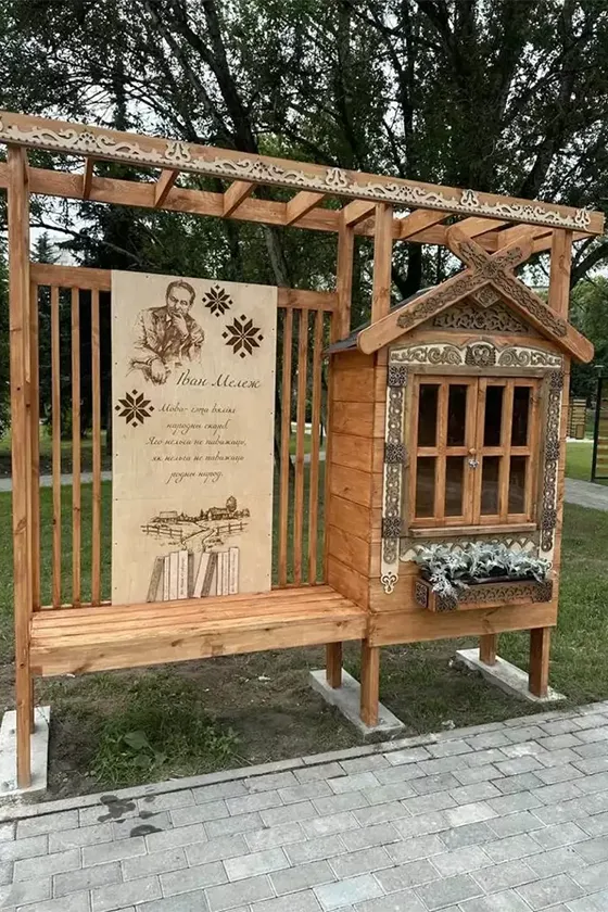 Резная деревянная стойка для буккроссинга с портретом Ивана Мележа в сквере на улице Гамарника