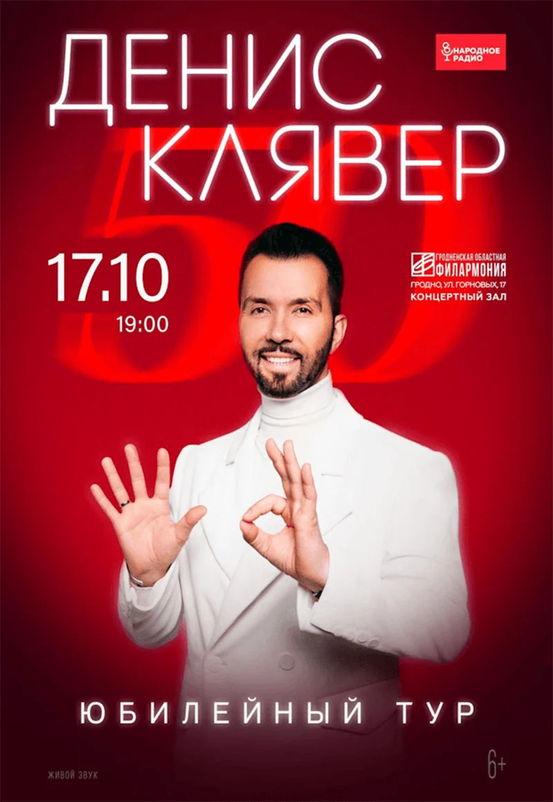 Денис Клявер на сцене с микрофоном во время юбилейного концерта